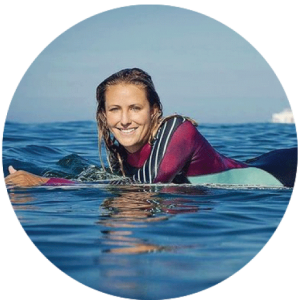 wavehuggers owner helina laying on a surfboard in the ocean in southern california